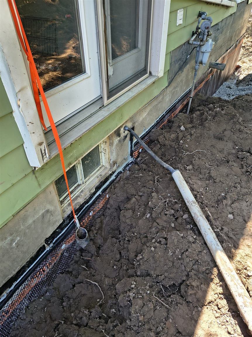 Foundation wall waterproofed and backfilled